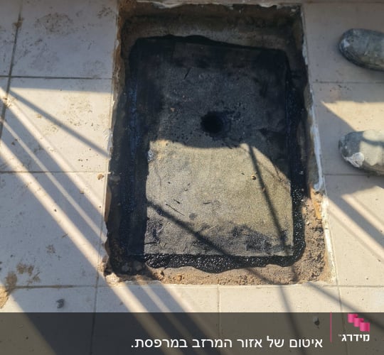 אזור מרובע עם חומר איטום שחור על רצפה